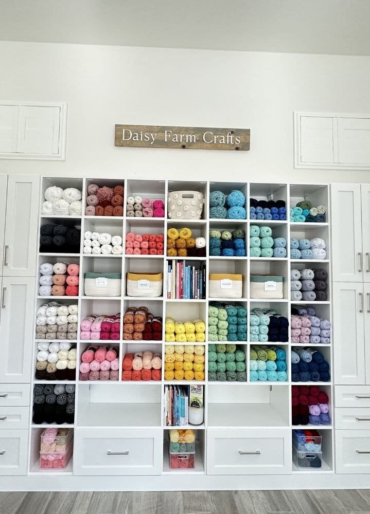 A room filled with closets full of many different colors of yarn, expertly organized by a professional organizer.