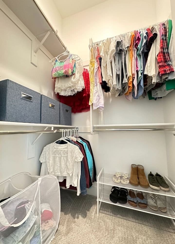 A professional organizer helps to arrange and declutter walk-in closets, organizing clothes and utilizing baskets for efficient storage.