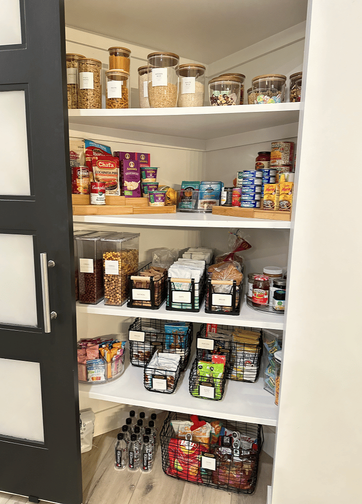 A pantry organized by a professional organizer with a lot of food in it.