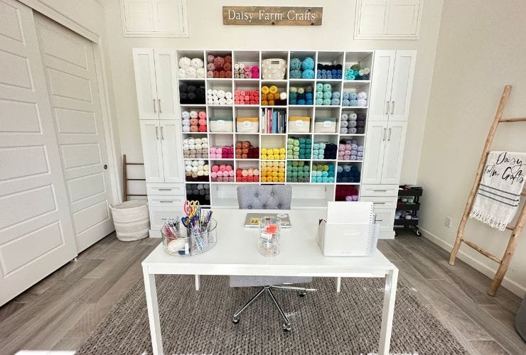 A white desk in a craft room with lots of supplies, organized by a professional organizer.