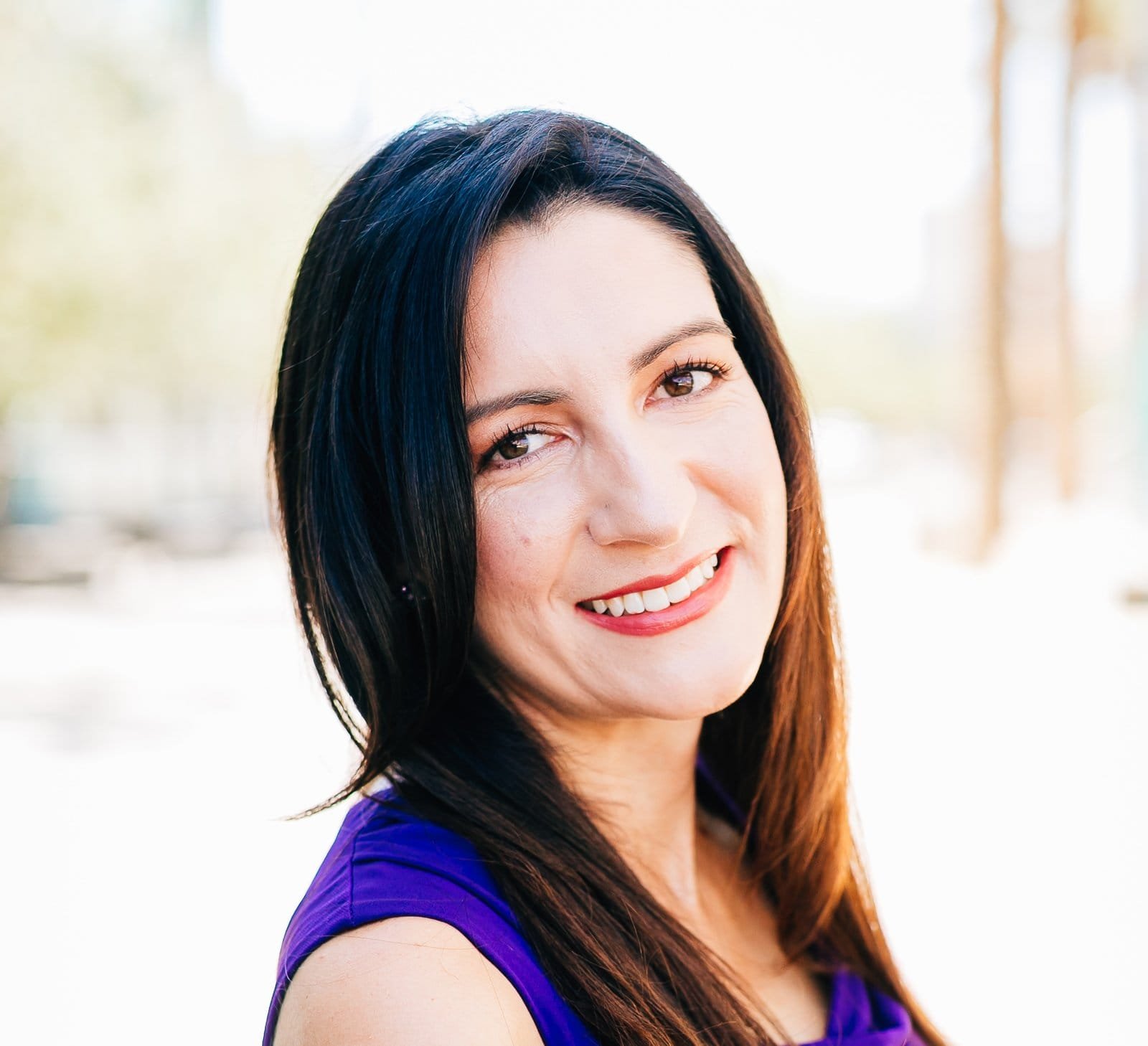 A professional organizer in a purple top smiles for the camera.