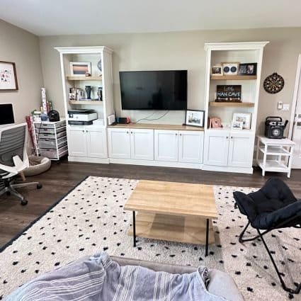 A professionally organized living room with a TV and a coffee table.