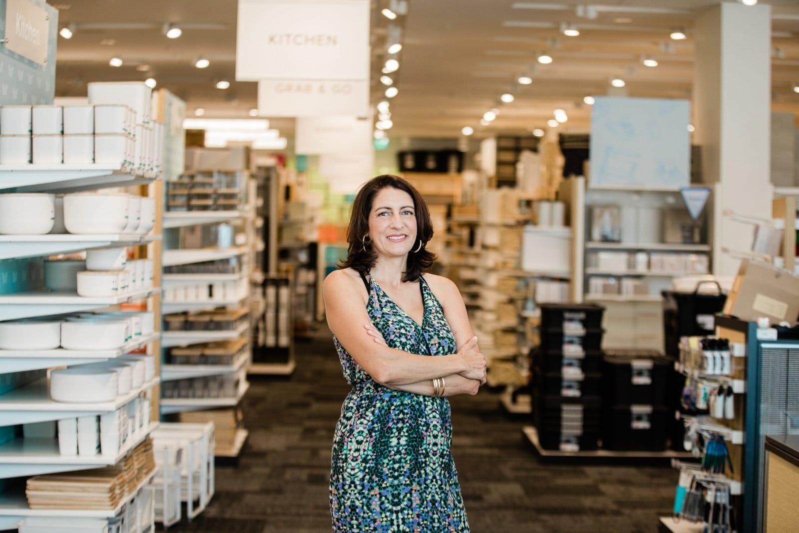 A professional organizer standing in front of shelves in a store.