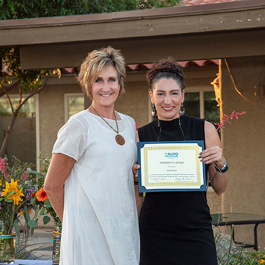 Two professional organizers standing next to each other holding a certificate.