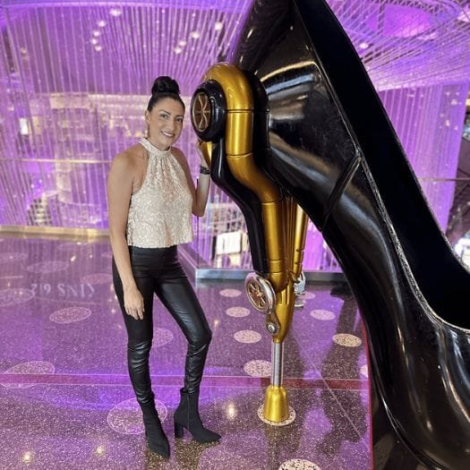 Sarah Nieto who works as a professional organizer posing next to a high heeled shoe.